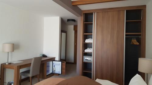 ein Hotelzimmer mit einem Schreibtisch und einem Schlafzimmer in der Unterkunft Jahorina Apartment 226 in Aparthotel Vucko in Jahorina
