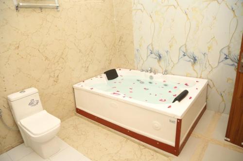 a bathroom with a bath tub and a toilet at The Gold Mount Villa in Udaipur