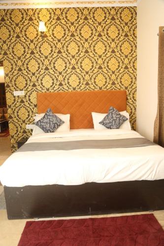 a bedroom with a large bed with a wall at The Gold Mount Villa in Udaipur