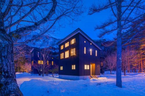 a house in the snow at night at Powdersuites by The Hakuba Collection in Hakuba