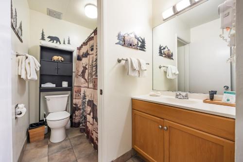 a bathroom with a toilet and a sink and a mirror at Cozy Studio w/ Partial Lake view #223 at Donner Lake Village in Truckee