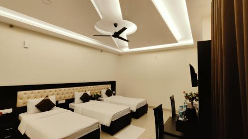 a bedroom with two beds and a ceiling fan at J P PALACE in Kushinagar