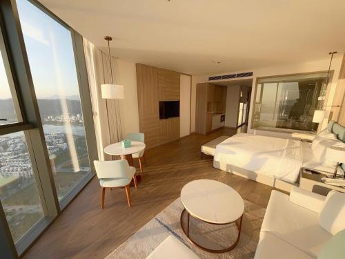 a hotel room with a bed and a large window at Căn hộ tại các tòa ICON40 - ALACARTE - NEW LIFE TOWER in Ha Long