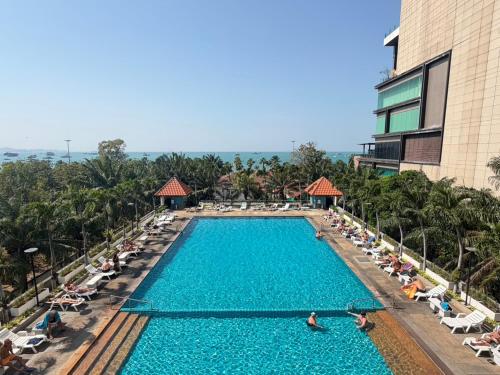 a pool at a resort with people sitting in chairs at View Talay 6 Pattaya Beach by Anatolia Condo Suite in Pattaya