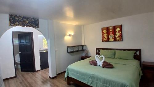 a bedroom with a bed with a heart pillow on it at Lemongarden in Ko Lanta