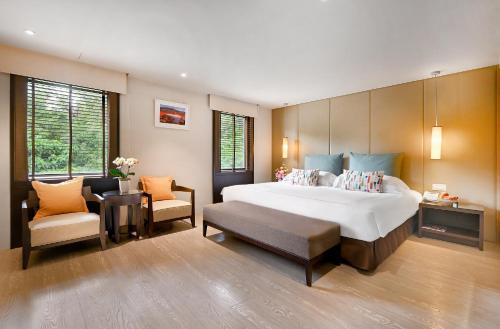 a large bedroom with a large bed and two chairs at The Gaia Hotel - Taipei in Taipei