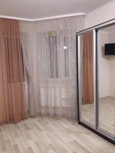 a room with a window with a curtain and a mirror at Квартира-студія центр Огієнка 2а in Lutsk