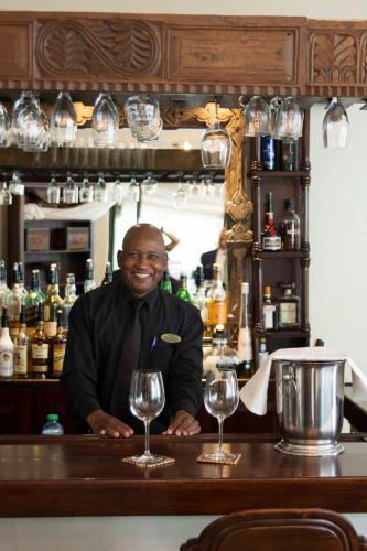 a man sitting at a bar with two wine glasses at Palacina The Residence & The Suites in Nairobi
