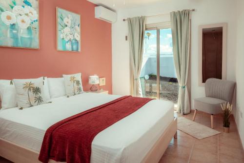 a bedroom with a large white bed and a window at Villa Solara in Caleta De Fuste
