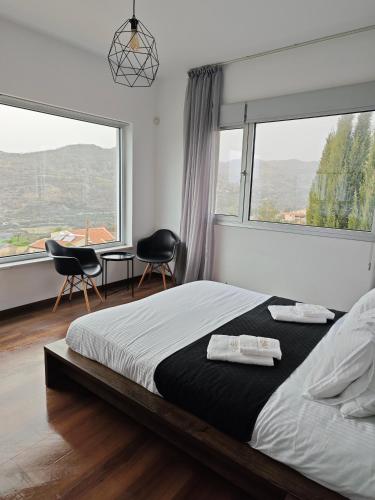 a bedroom with a bed and two chairs and windows at Maximos Luxury Villa Monagri Limassol in Monagri