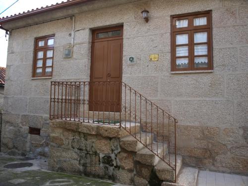 a stone house with a wooden door and stairs at Casa de RioBom in Soajo