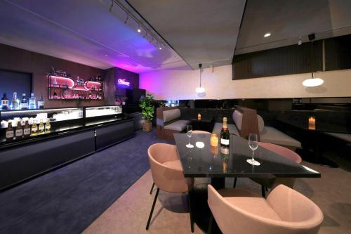 a restaurant with a table and chairs and a bar at Kuromon Crystal Hotel in Osaka
