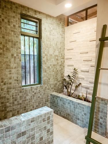 a bathroom with a tub and a window at Barren House in Hiriketiya
