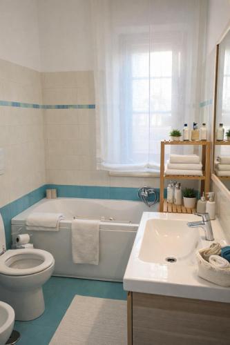 a bathroom with a tub and a toilet and a sink at Appartamento L'Olivo in Latina