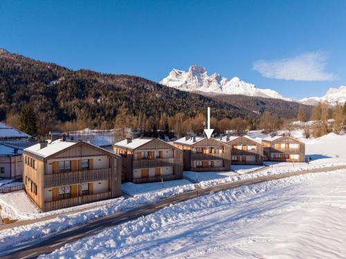 a group of buildings in the snow with a mountain at GreenWood Chalet - Spacious Alpine Retreat with Mountain Views in Vodo Cadore