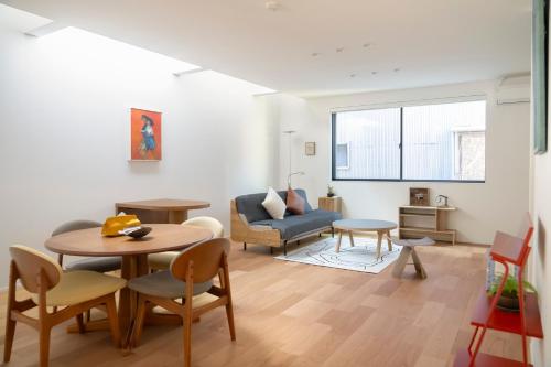 a living room with a table and a couch at USJ 梅田 大阪城へ直通 駐車場付きモダン一軒家 JR弁天町駅3分 LIRI Kasumi in Osaka