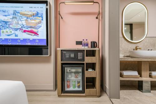 a bathroom with a tv and a refrigerator at Mercure Beijing Anzhen Olympic Center in Beijing