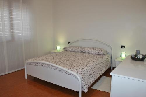 1 dormitorio con 1 cama blanca y 2 mesitas de noche en Casa Mattia by Holiday World, en Bellano