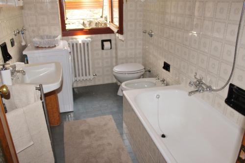 y baño con bañera, aseo y lavamanos. en Casa Mattia by Holiday World, en Bellano