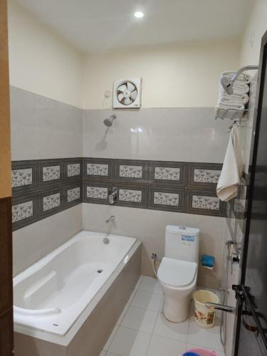 a bathroom with a bath tub and a toilet at J P PALACE in Kushinagar