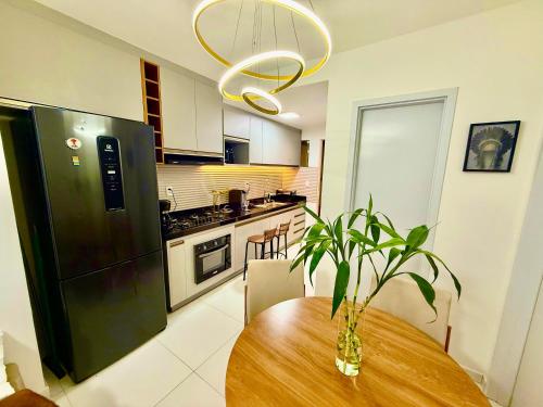 a kitchen with a table with a plant on it at Apartamento em Condomínio Clube Completo com Piscina in Vitória da Conquista
