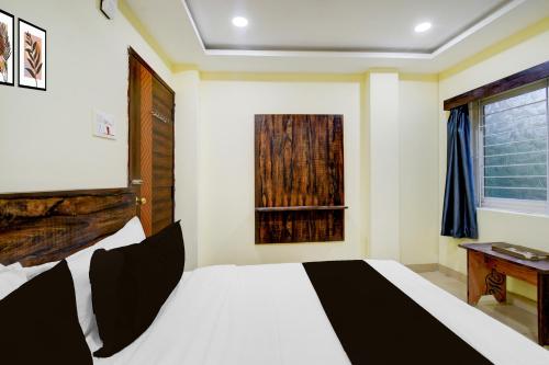 a bedroom with a white bed and a window at Hotel O Hotel R Pacific in Hyderabad