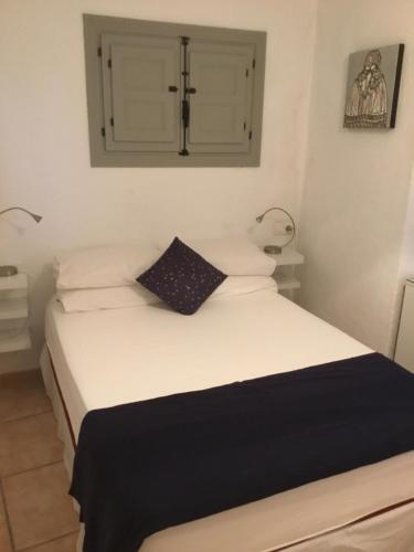 a bedroom with a white bed with a cross on the wall at Apartment Rincón in Mojácar