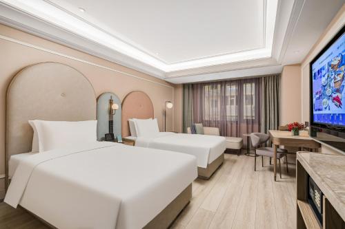 a hotel room with two beds and a flat screen tv at Mercure Beijing Anzhen Olympic Center in Beijing