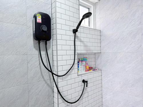 a shower with a black shower head on a wall at Ban Belife14 in Ban Tha Chin (1)