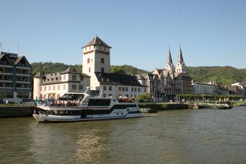 a boat in a river in front of buildings at Rheinhotel Lilie in Boppard
