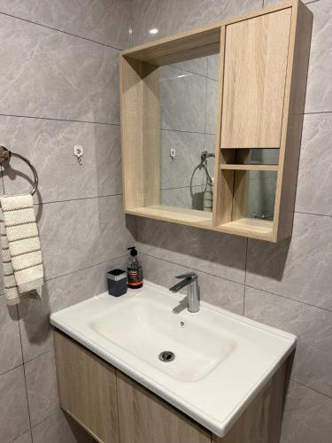 a bathroom with a sink and a mirror at Homiq Stays near UN & Village Market - 1 bedroom in Ruaka