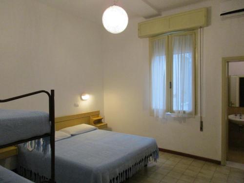 a bedroom with two beds and a window and a sink at Hotel Pensione Ornella in Cesenatico
