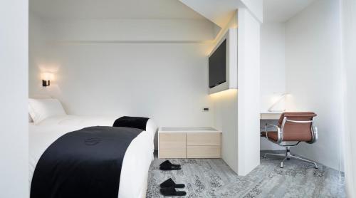 a bedroom with a bed and a desk and a chair at Swiio Hotel Daan in Taipei