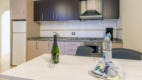 a kitchen with a table with a bottle of wine at Villa del Mar in Patalavaca