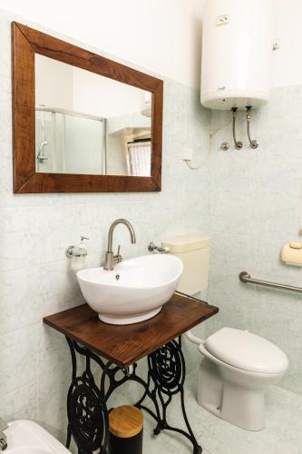 a bathroom with a sink and a toilet and a mirror at Apartment Valetovi in Štanjel