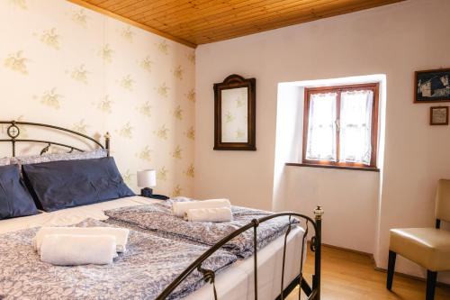 a bedroom with a bed and a chair and a window at Apartment Valetovi in Štanjel