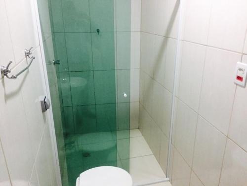 a bathroom with a toilet and a glass shower at Hotel Flert Santana in Sao Paulo