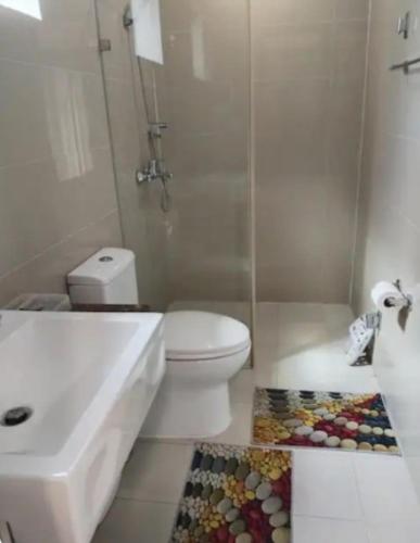 a bathroom with a white toilet and a sink at The Layover Condotel ,Palm Tree two Villas ,cluster 2 - unit 7q , New Port Boulevard , Newport City ,NAIA Terminal 3 , Pasay City , Philippines in Sampong