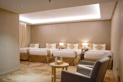 a hotel room with two beds and a couch at Finda Hotel in Medina