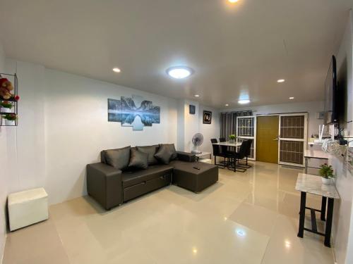 a living room with a couch and a table at NB Bangsaen House in Ban Puk (2)