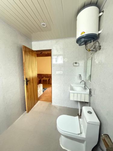 a bathroom with a toilet and a sink at Vezara homestay in Kūfrī