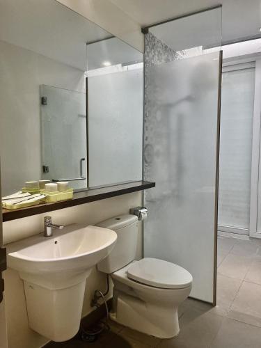 a bathroom with a toilet and a sink and a mirror at Oceanami Resort beach club in Long Hai