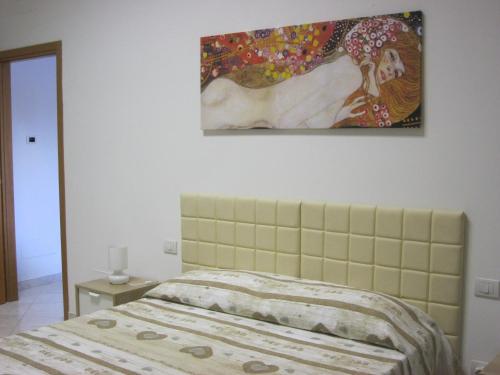 ラ・スペツィアにあるLa casa di Marisaのベッドルーム1室(ベッド1台付)が備わります。壁には絵画が飾られています。