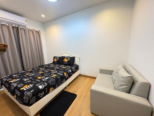 a bedroom with a bed and a couch at NB Bangsaen House in Ban Puk (2)