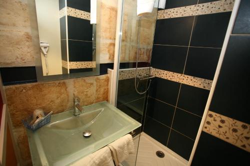 a bathroom with a sink and a shower at Hôtel La Tour Intendance in Bordeaux
