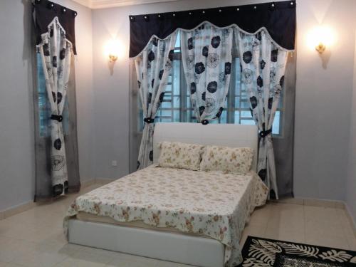 a bedroom with a bed and a window with curtains at The Louvre Moslim Homestay Sungai Petani in Sungai Petani