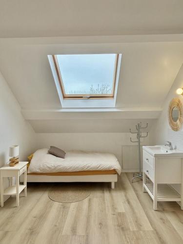 a bedroom with a bed and a window at Maison Les Sardines in Cucq