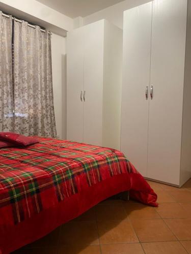 a bedroom with white cabinets and a red blanket on a bed at Irnohouse in Salerno