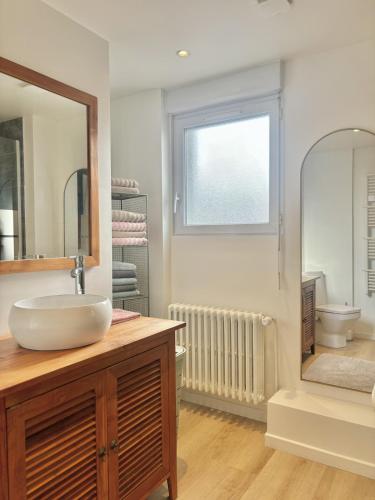 a bathroom with a sink and a mirror and a toilet at Maison Les Sardines in Cucq