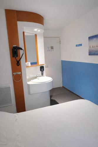 a bathroom with a sink and a mirror and a bed at Quick Palace Saint Brieuc in Tregueux